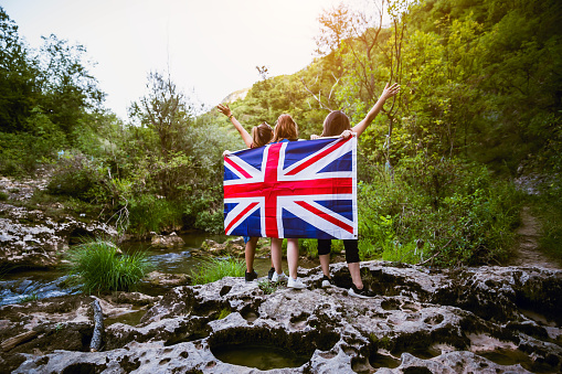 Happy Women holding British flag in nature