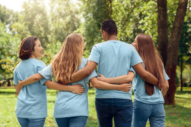 istock Volunteering. Young people volunteers outdoors walking hugging back view talking laughing cheerful 1187918636