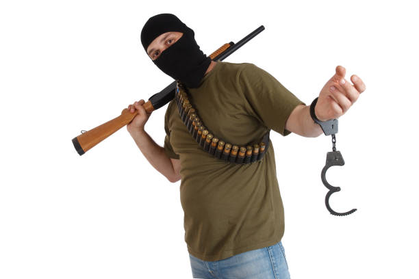 istock jail break - robber in black mask with shotgun removing handcuffs 1187920414