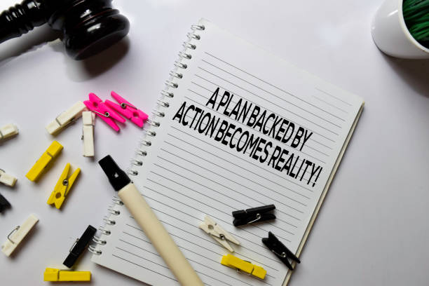 istock A Plan Backed By Action Becomes Reality! text on a book at office desk. Motivation concept 1187921116