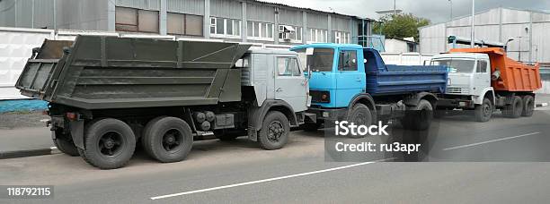 Photo libre de droit de Gris Bleus Et Orange Camions Sur La Route banque d'images et plus d'images libres de droit de Arbre sans feuillage - Arbre sans feuillage, Au bord de, Blanc