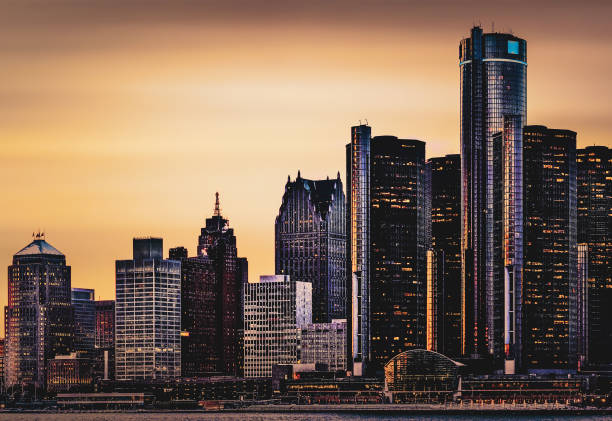 Detroit, Michigan - Skyline at Dusk The Detroit skyline as seen from across the Detroit River, in Windsor, Ontario, Canada. detroit michigan stock pictures, royalty-free photos & images