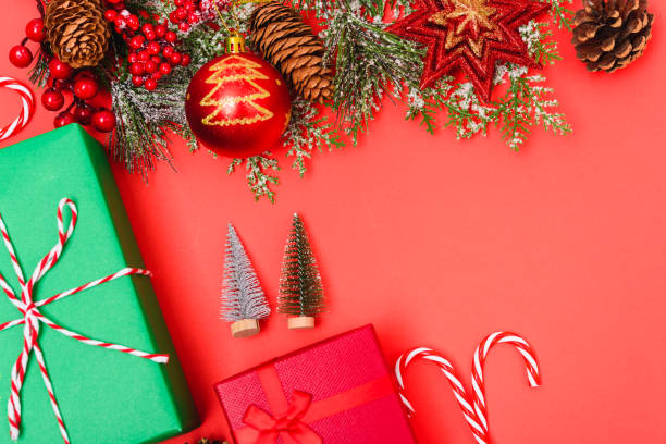 istock Christmas green gift box and decorations, fir tree branches on red background 1187936433