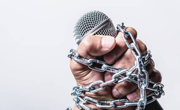 istock Hand holding microphone and have chain on fist hand on white background 1187937012