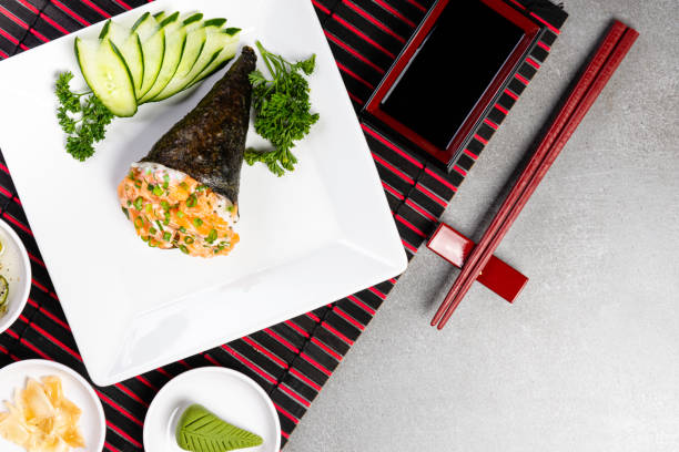 灰色の背景に黒い皿にサーモンのたてき寿司。日本料理。トップ ビュー - temaki food sushi salmon ストックフォトと画像