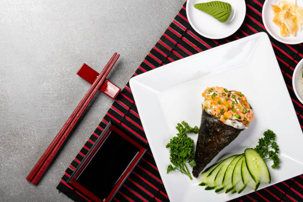 灰色の背景に黒い皿にサーモンのたてき寿司。日本料理。トップ ビュー - temaki food sushi salmon ストックフォトと画像