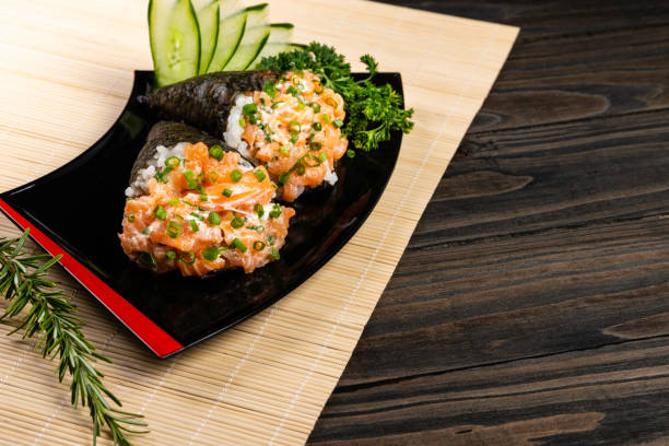 黒い皿に黒い背景にサーモンのてだみ寿司 - temaki food sushi salmon ストックフォトと画像