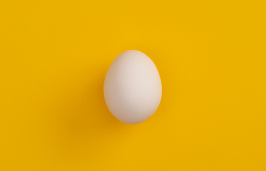 White egg on yellow background.