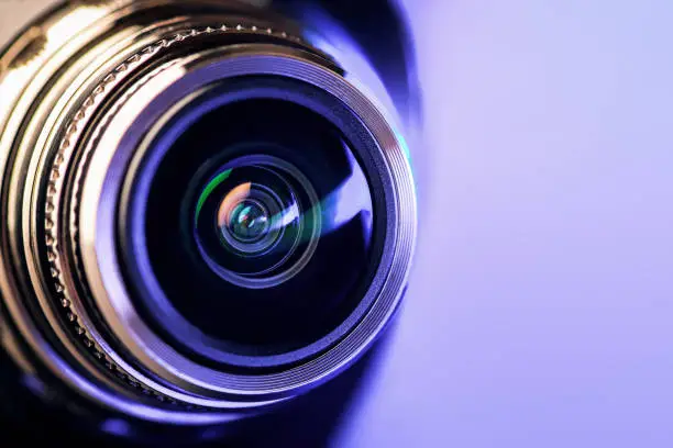Photo of The camera lens with purple backlight. Optics. Gorizontal photo