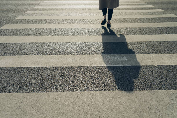 istock Blurry zebra crossing with pedestrians walking shadows 1187952800