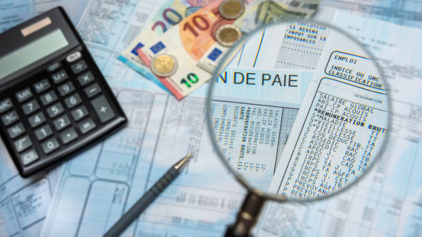 buste paga francesi con calcolatrice, contanti in euro e una lente d'ingrandimento - wages foto e immagini stock