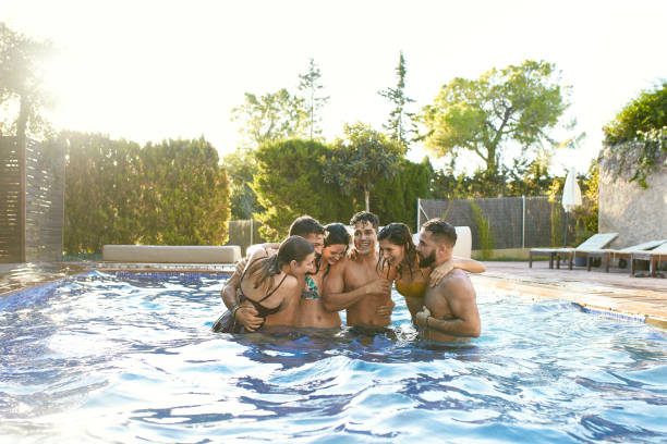 istock Young Friends Laughing and Hugging in Swimming Pool 1187954871