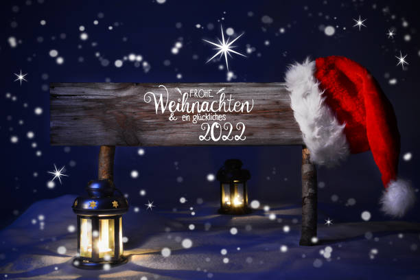 Christmas Night With Snow, Lamp, Santa Hat, Happy 2022 Means Happy 2022 Sign With German Calligraphy Frohe Weihnachten Und Glueckliches 2022 Means Merry Christmas And Happy 2022. Peaceful Christmas Night With Snow And Lamp. german language photos stock pictures, royalty-free photos & images