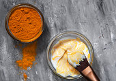 Natural face mask with turmeric powder and yogurt. Natural cosmetics on a gray background