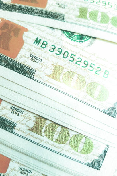 istock One hundred dollar bills on the table as background. 1187968130