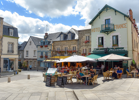 JOSSELIN, FRANCE - JULY 2, 2017: Tourists enjoying on the terraces of a sunny day in Josselin, a French town, located in the Brittany region