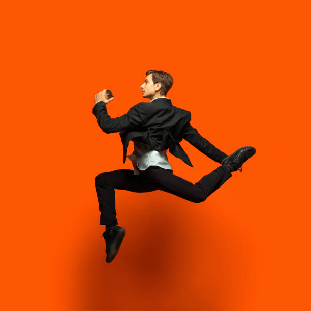 istock Man in casual office style clothes jumping isolated on studio background 1187976795