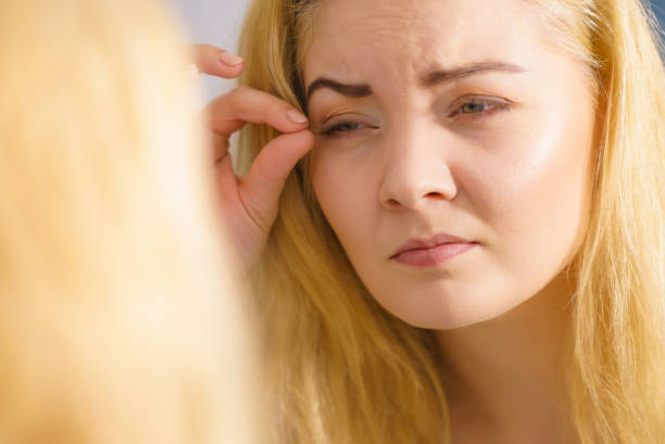 istock Woman looking at her skin in mirror 1187979135