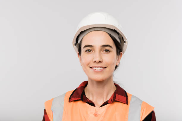 istock Pretty young smiling female builder in hardhat and working vest looking at you 1187980357