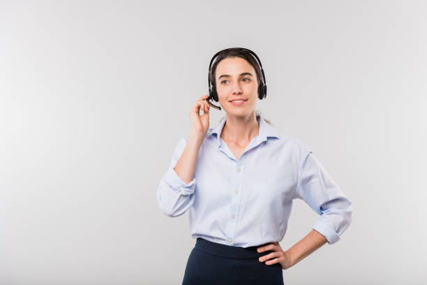 feliz operador elegante jovem com fones de ouvido consultando clientes on-line em isolamento - women customer service representative service standing - fotografias e filmes do acervo