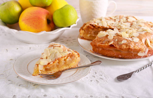 istock Slice of apple pie with icing and almond topping 1187980486