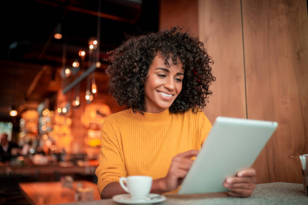istock Smiling young woman using digital tablet 1187986660
