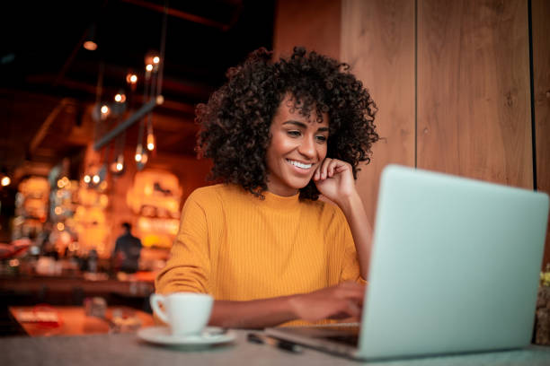 istock Young woman using a laptop at a cafe 1187987249