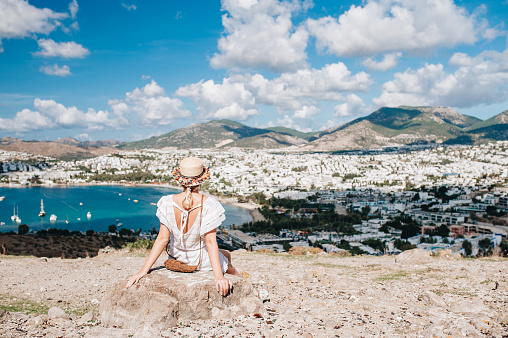 Woman sitting and enjoyng amazing view of Bodrum bay from the high. Turkey