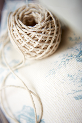 Shot of a bundle of thread over white fabric