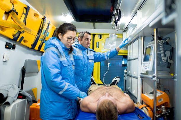 istock Paramedic examining sick man on stretcher while her colleague preparing dropper 1187991269