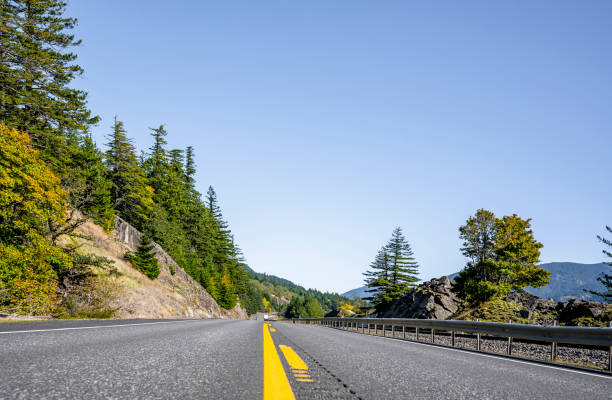 istock Straight road between cliffs with yellowed autumn trees 1187992297