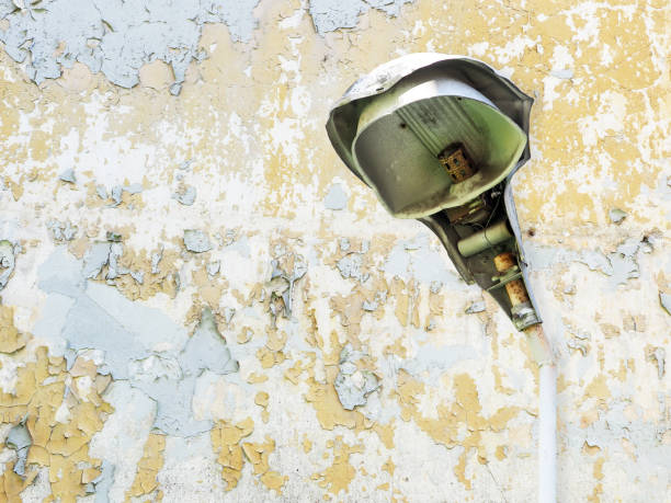 Peeling wall and old broken lamp, disrepair concept
