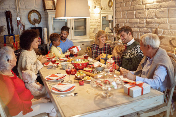 istock family enjoy on Christmas dinner and exchange present together 1187994972