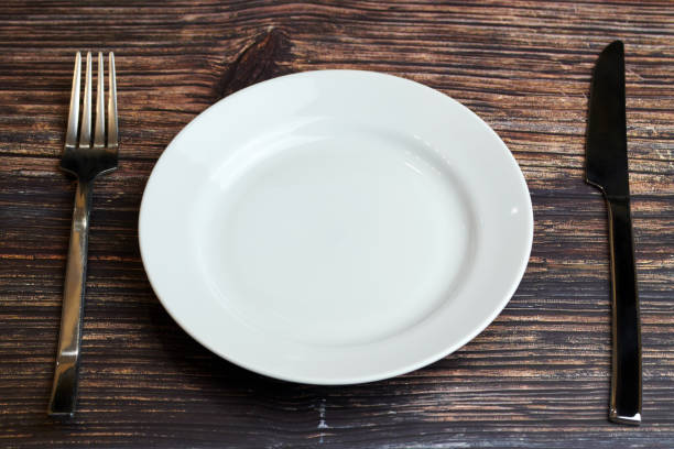 istock Empty plate on table with cutlery. Visitor of an luxury restaurant is waiting for an order. Restaurant business went broke concept 1187998437