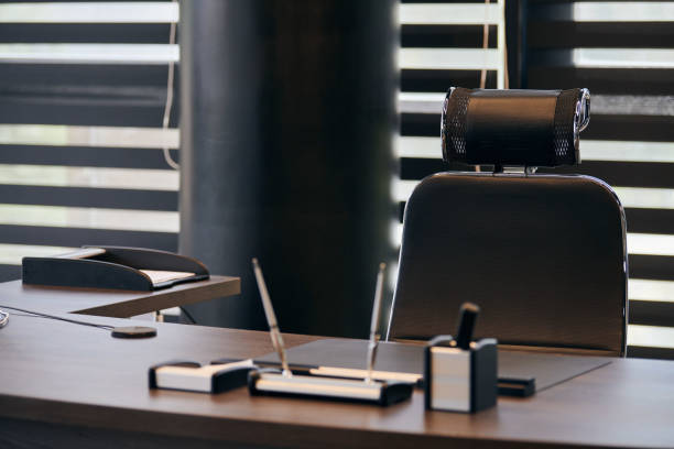 istock Business office workplace. Work place for chief, boss or other employees. Table and comfortable chair. Light through the half open blinds 1187998526
