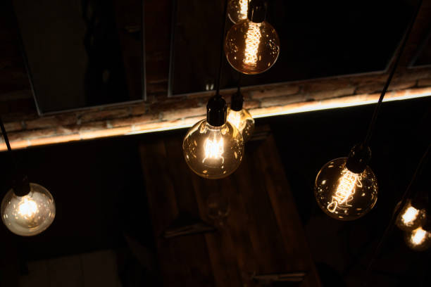 istock Warm glowing glass light bulbs hanging from the ceiling 1187999533