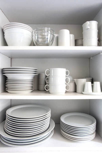 istock White Cupboard with white crockery in the kitchen, various clean dishes 1187999782