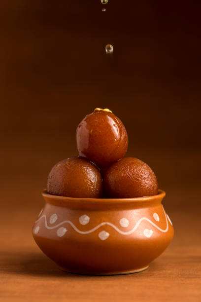Gulab Jamun in clay pot. Indian Dessert or Sweet Dish Gulab Jamun in clay pot with spoon and dry fruits. Indian Dessert or Sweet Dish india sweets stock pictures, royalty-free photos & images