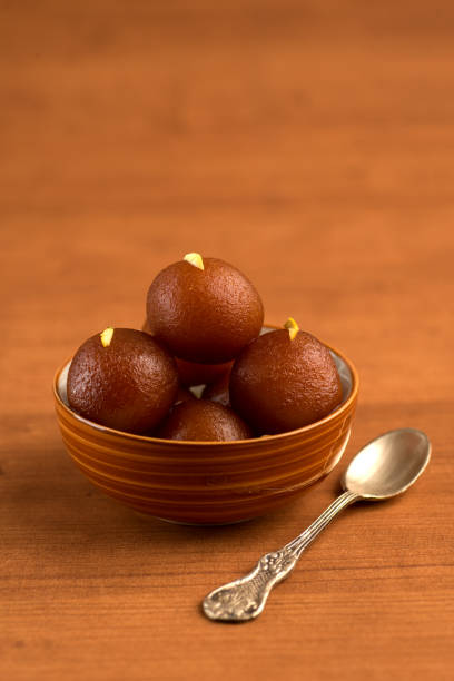 Gulab Jamun in bowl on wooden background. Indian Dessert or Sweet Dish. stock photo