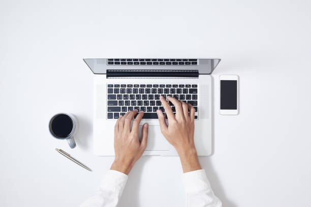 istock A man is typing on laptop keyboard on modern white office desk, top view 1188001731