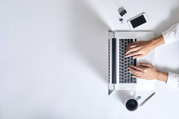 istock A man is typing on laptop keyboard on modern white office desk, top view 1188001767