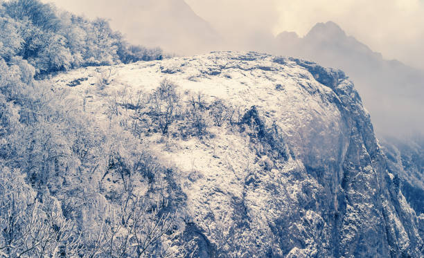 istock mountain cliff in a snow and mist, winter outdoor background 1188003155