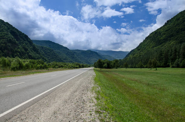 istock Empty asphalt road highway in the forested mountains, on the background a cloudy sky 1188007800
