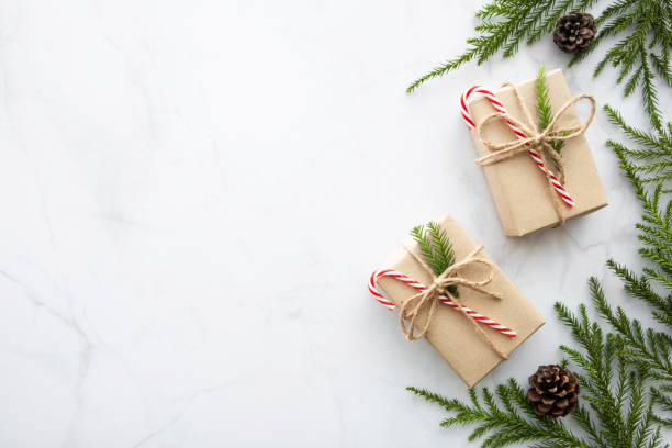 istock White marble table with Christmas decoration including giftbox, candy cane, pine branches and pine cones. Merry Christmas and happy new year concept. Top view with copy space, flat lay. 1188008643