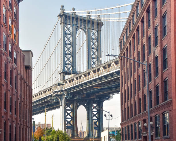 vista icónica del puente de manhattan desde washington street. edificios callejeros de ladrillo rojo que conducen al puente al atardecer. brooklyn. nyc, estados unidos - new york city brooklyn new york state bridge fotografías e imágenes de stock