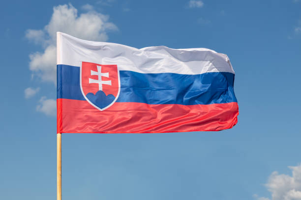 Slovak national flag waving on the wind on blue sky backgroundwith white clouds