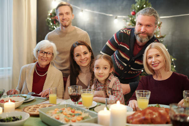 istock Big family looking at you while sitting by served table in front of camera 1188009384