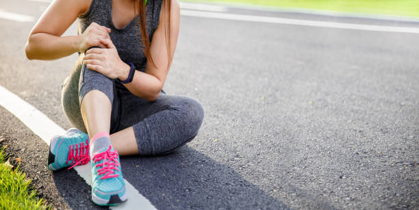 atleta corridore femminile infortunio alle gambe e dolore. donna che soffre di gamba dolorosa mentre corre nel parco. - twisted ankle immagine foto e immagini stock