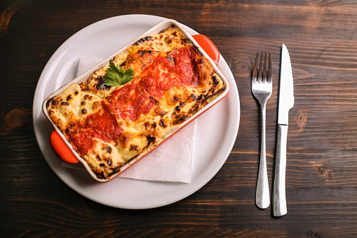 Traditional Italian Lasagne on a wooden background.