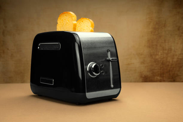istock black silver toaster with baked finished toast on a brown table with brown textured background neutral silver colors 1188015119